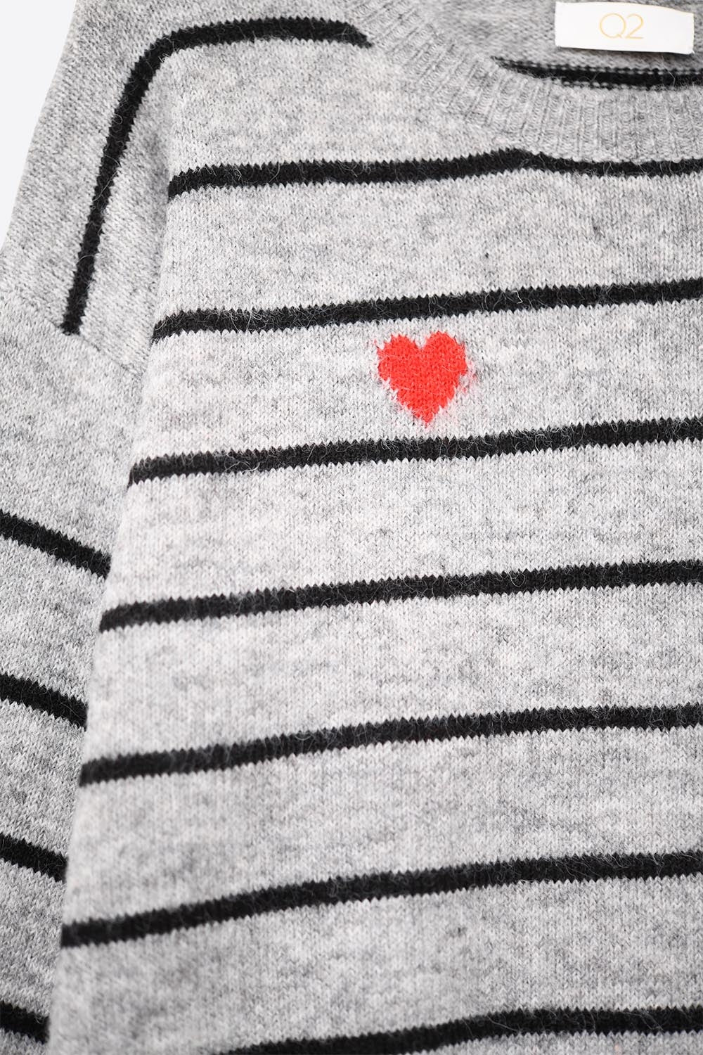 Maglione nero con dettaglio cuore rosso e strisce bianche.