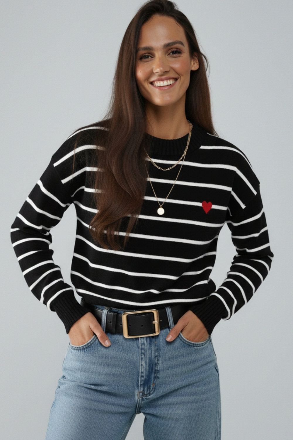Maglione nero con dettaglio cuore rosso e strisce bianche.